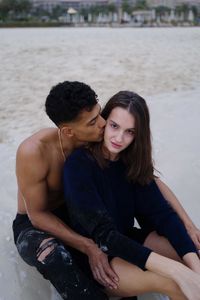 Portrait of young couple  sitting at beach