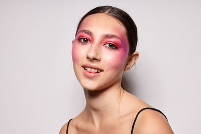 Close-up of young woman against white background