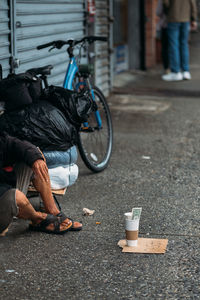 Low section of woman sitting on street