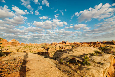 Photographer's shadow on red rocks at sunrise at camp in utah