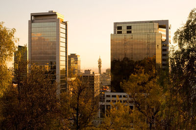 Buildings in city against sky during sunset