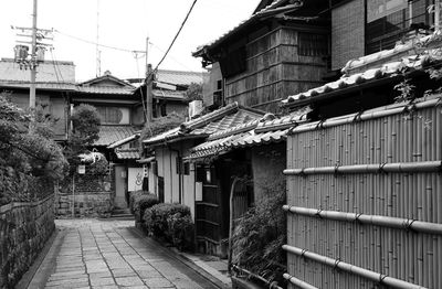 Houses by street in town against sky