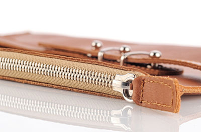 Close-up of purse on table against white background