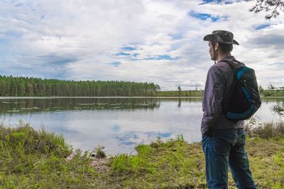 Rear view of man standing in water against sky