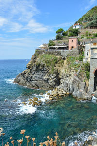 Scenic view of sea by buildings against sky