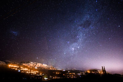 Illuminated cityscape against sky at night