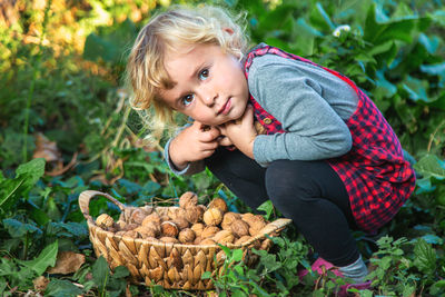 Portrait of cute girl picking vegetables at farm