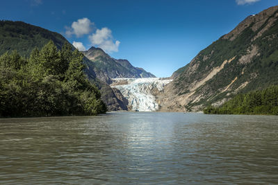 Scenic view of lake by mountains against sky