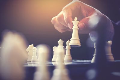 Cropped hand of woman holding chess pieces