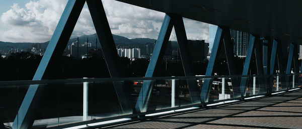 Bridge over river in city against sky