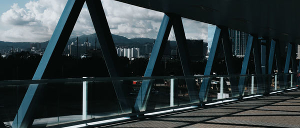 Bridge over river in city against sky