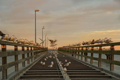 View of steps leading towards sea against cloudy sky