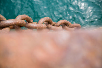 Close-up of rusty metal chain on shore