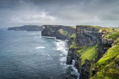 Group of people sightseeing iconic cliffs of moher, ireland