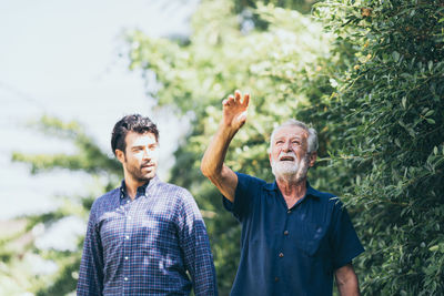 Friends standing against plants