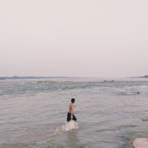 Woman on beach against clear sky