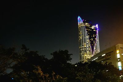 Low angle view of illuminated skyscraper against sky at night