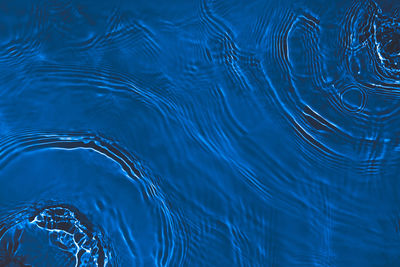 Transparent dark blue colored clear calm water surface texture