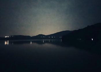 Scenic view of lake against sky at night