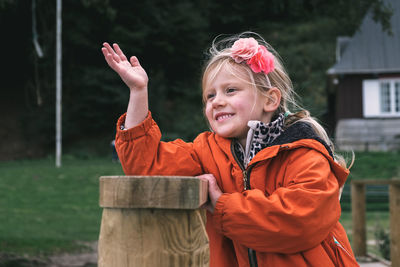 Close-up of smiling girl waving