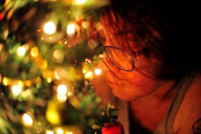 Close-up of woman by christmas tree