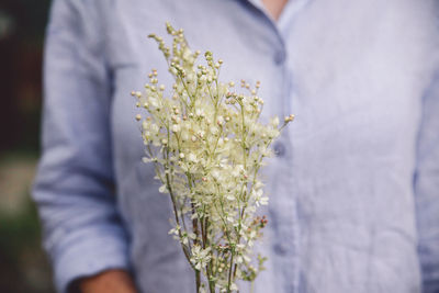 Midsection of woman with flower bouquet