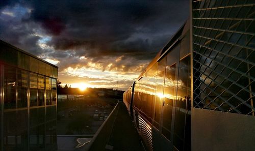 Train on railroad tracks in city during sunset