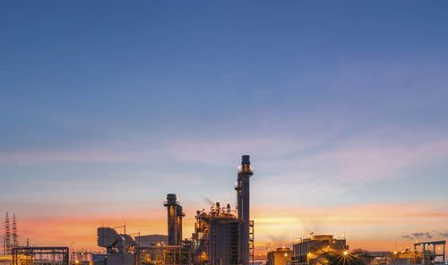 Factory against sky during sunset