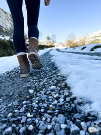 View of a girl's boots on a snowy path.
