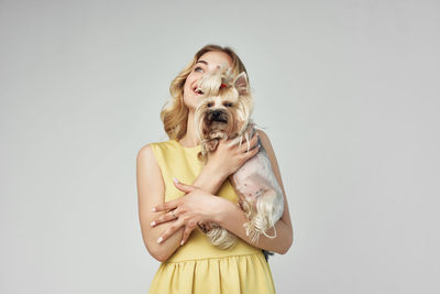 Woman with dog standing against white background