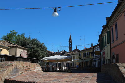 Houses on street against clear blue sky