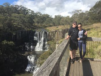 Couple standing by waterfall against plants