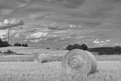 Hay bales on field against sky