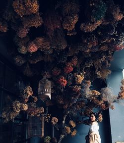 Side view of woman standing under plants