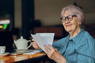 Smiling senior businesswoman reading document