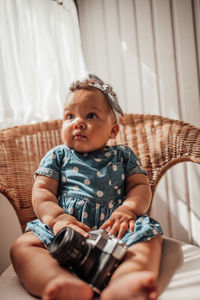 Cute boy sitting on sofa at home