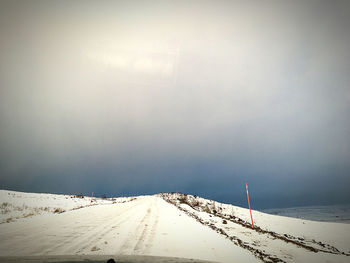 Snow covered road against sky