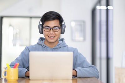 Young collage student using computer and mobile device studying