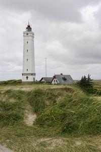 Lighthouse by sea against sky