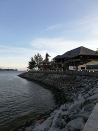 Scenic view of sea by buildings against sky