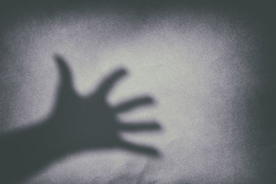 Shadow of person hand on wall