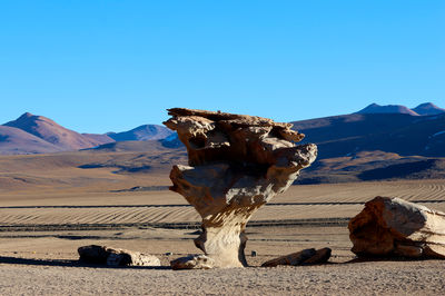 Scenic view of desert against clear blue sky