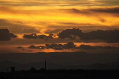 Scenic view of silhouette mountains against sky during sunset