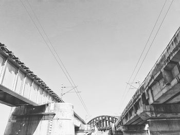 Low angle view of bridge and buildings against sky