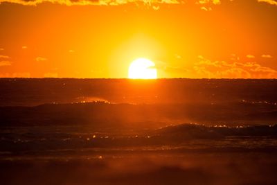 Scenic view of sea against orange sky