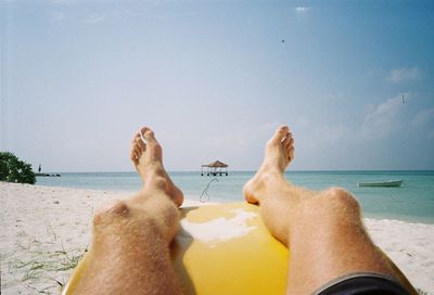 Low section of man relaxing on beach
