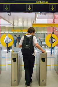 Rear view of man standing at railroad station