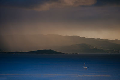 Scenic view of sailboat in sea against sky during sunset