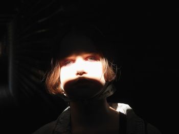 Portrait of boy against black background