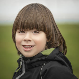 Small boy portrait on green background at autumn